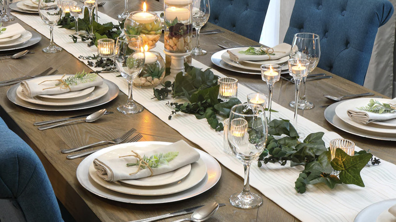 table set with candles and glass vases filled with and succulents