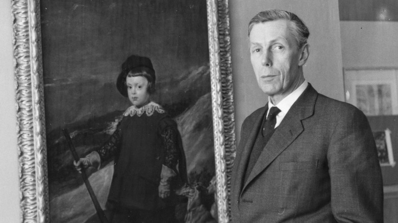 Anthony Blunt posing next to painting