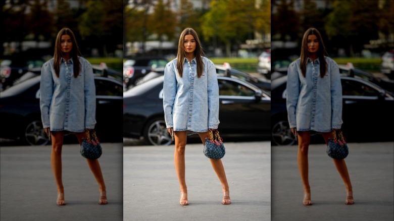 Woman posing wearing clear heels, denim dress