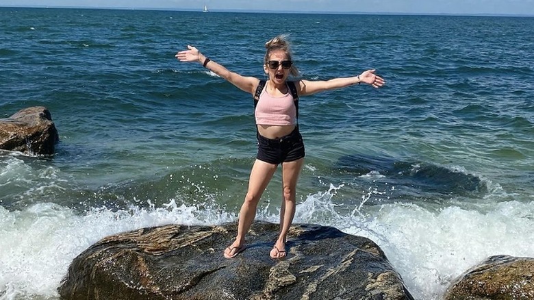 Shauna Rae standing on a rock by water