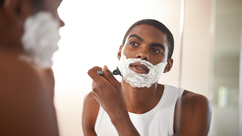 Man shaving in mirror