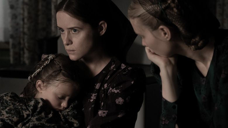 Claire Foy and Rooney Mara sitting with child in Women Talking