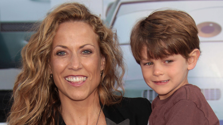 Sheryl Crow holding her son Wyatt, smiling