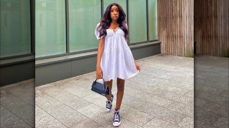 woman wearing white dress with black sneakers