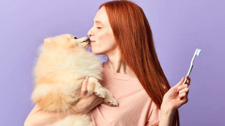 Woman kissing her puppy