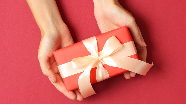 Woman holding out hands with a present