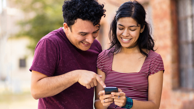 Hispanic couple looking at phone