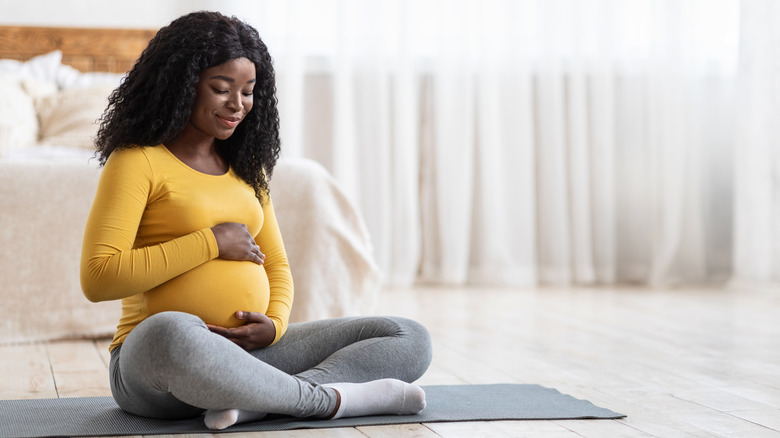 pregnant woman on yoga mat