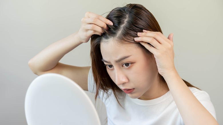 concerned woman checking scalp