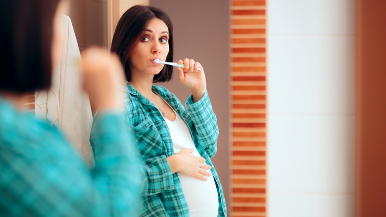 pregnant woman brushing teeth