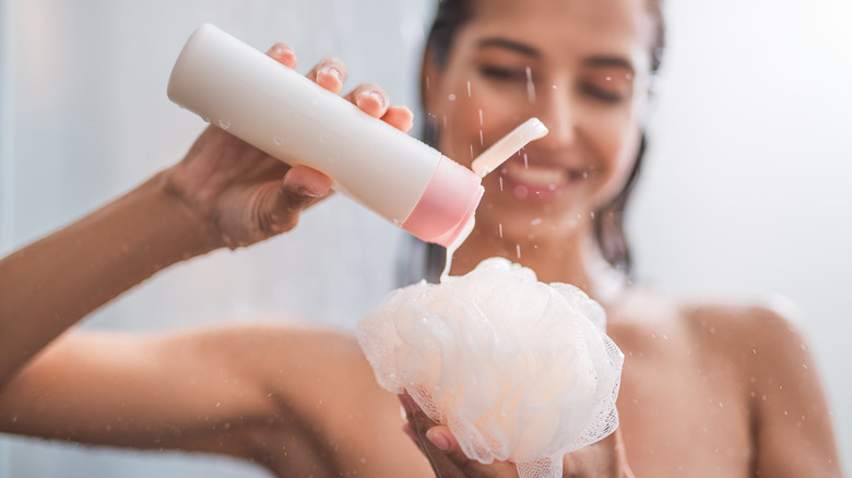 Woman putting body wash on loofah