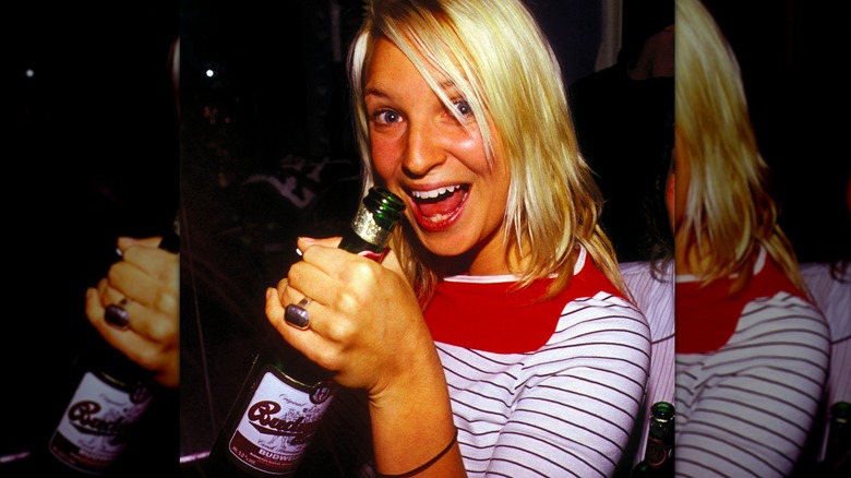 Sia holding beer bottle