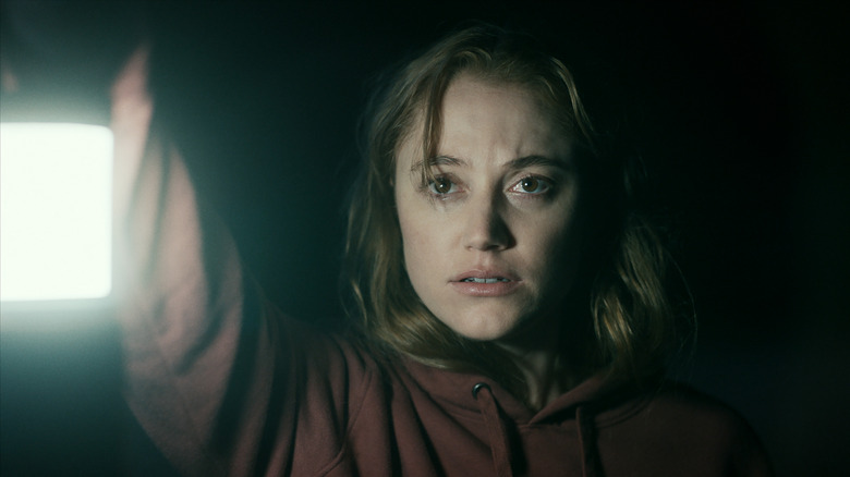 Maika Monroe holding flashlight in "Significant Other"