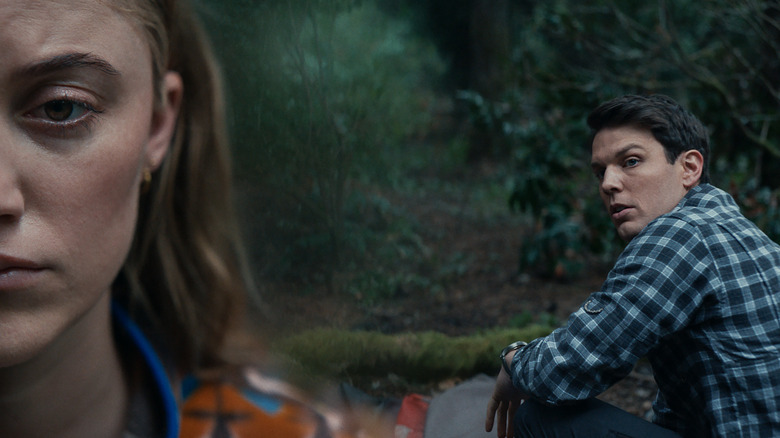 Maika Monroe and Jake Lacy looking worried in the forest