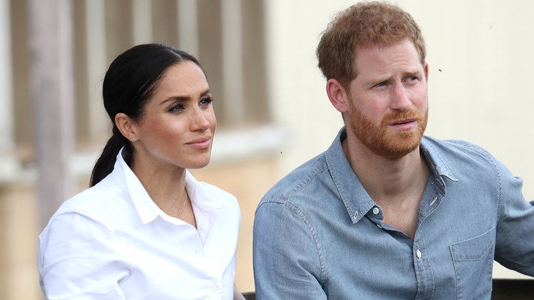 Meghan Markle and Prince Harry look apprehensively to the side