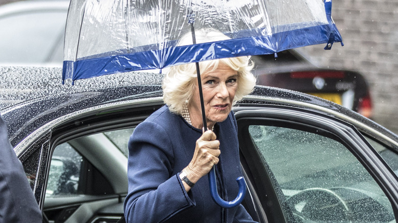 Camilla exits a car