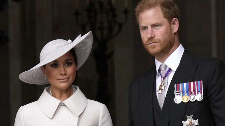 Prince Harry and Meghan Markle looking grim