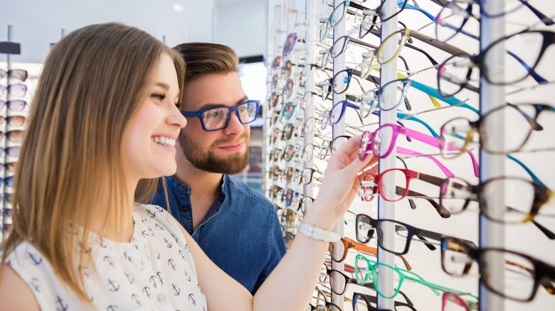 woman picking out glasses with man