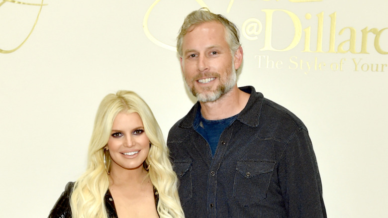 Jessica Simpson and Eric Johnson smiling, take a picture together at a spring style event