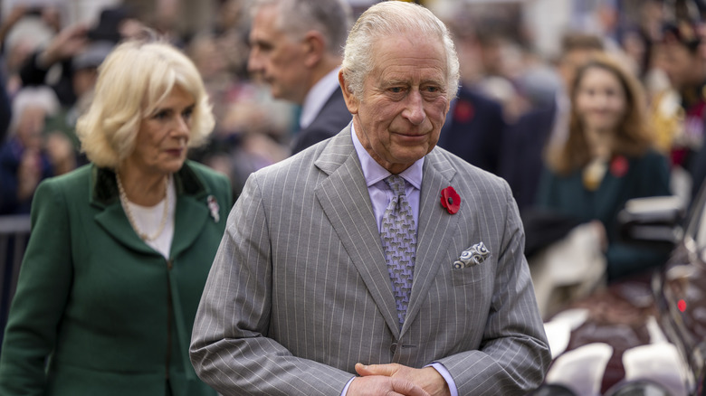 King Charles walks in front of Queen Camilla