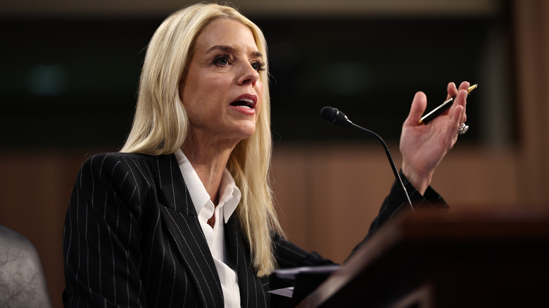 Pam Bondi speaking in a pinstripe suit