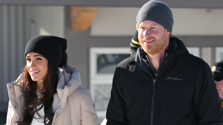 Prince Harry and Meghan Markle smiling outside