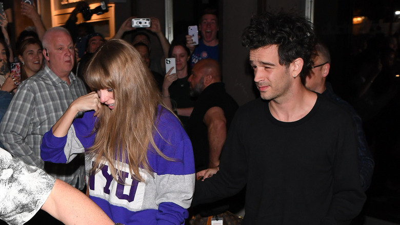 Taylor Swift and Matty Healy walking out 