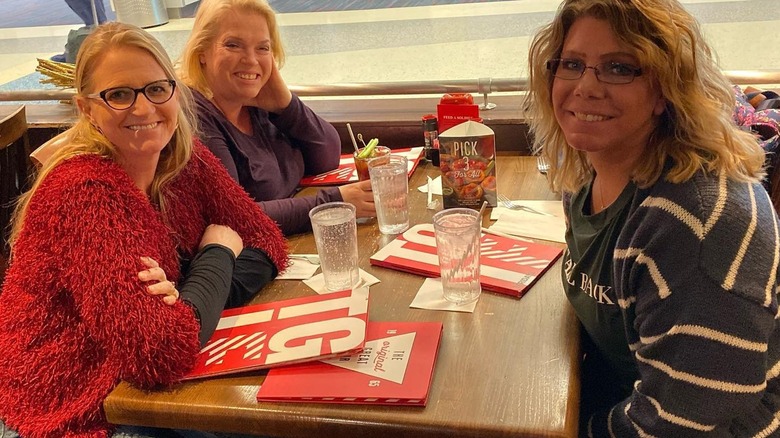 The Sister Wives sitting at a table, smiling