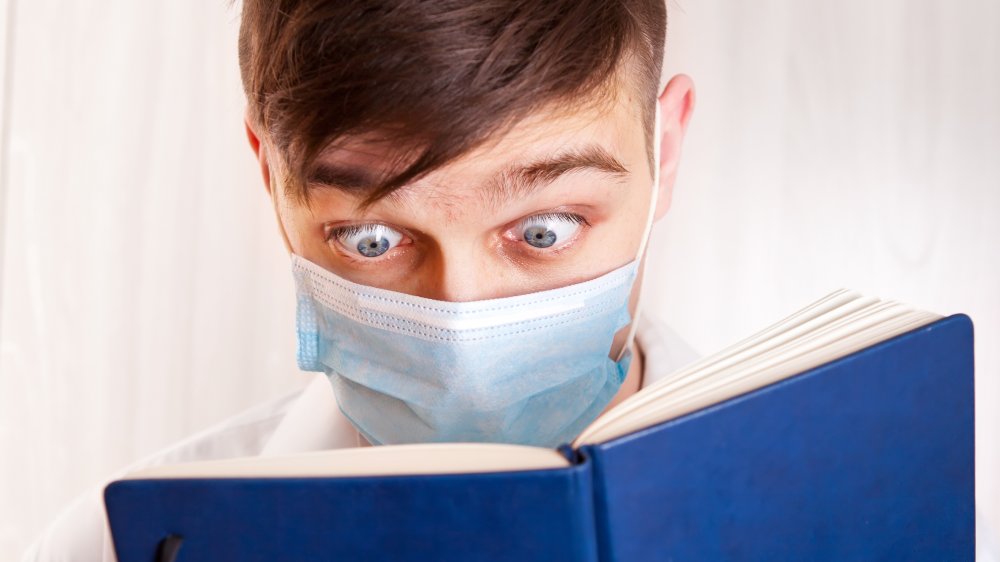 Person looking up symptoms in a medical book