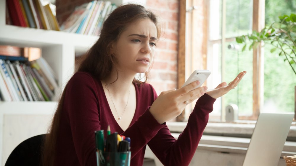 Woman feeling stress over texting