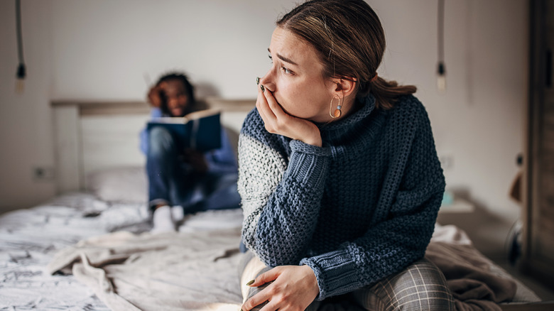 Upset woman sitting on bed