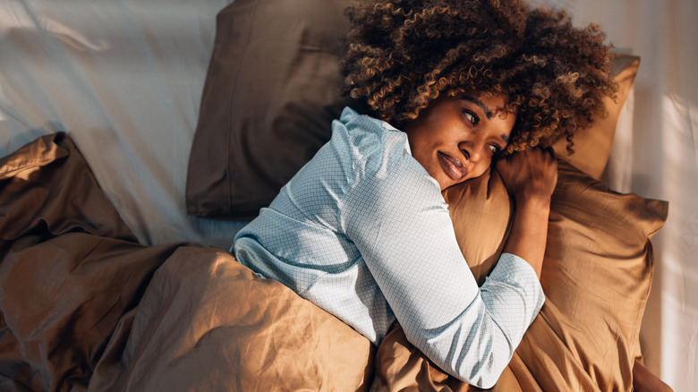 Woman reflecting in bed