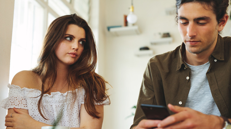 woman staring man on phone