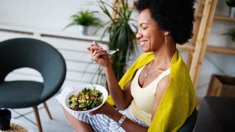 Woman smiling and eating salad