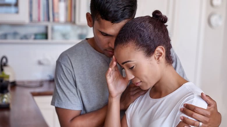 man comforting woman