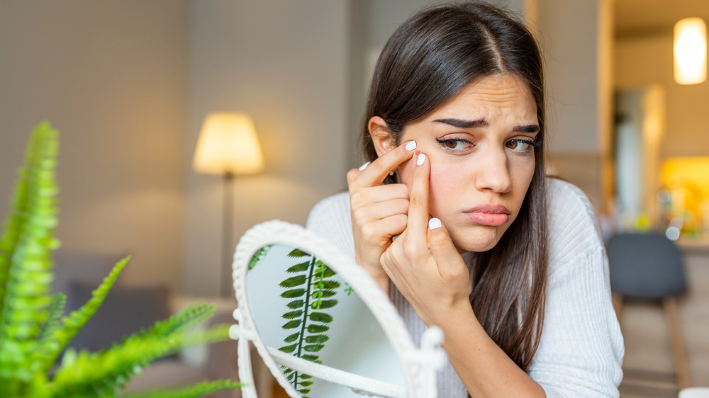 Woman popping her pimple