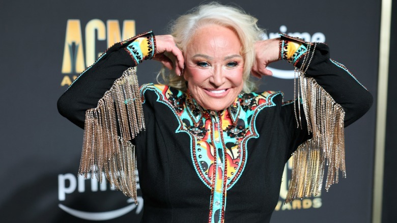 Tanya Tucker with arms up showing fringe