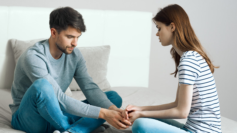 A couple arguing while holding hands