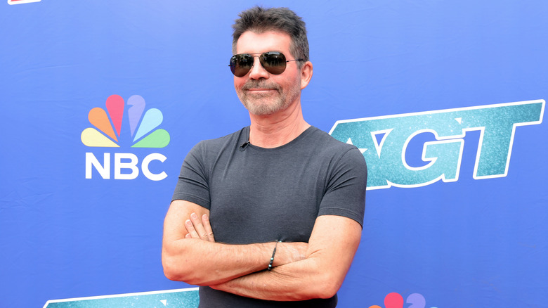 Simon Cowell smiling arms crossed