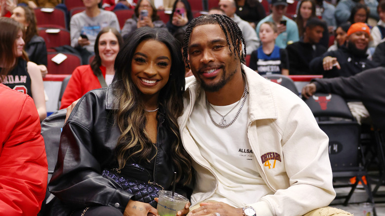 Simone Biles and Jonathan Owens pose at a basketball game