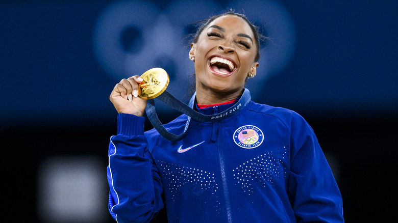 Simone Biles holding gold medal