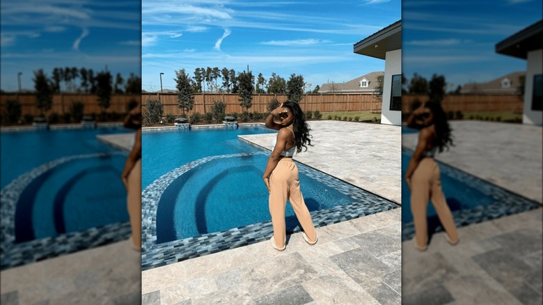 Simone Biles poses outside swimming pool 