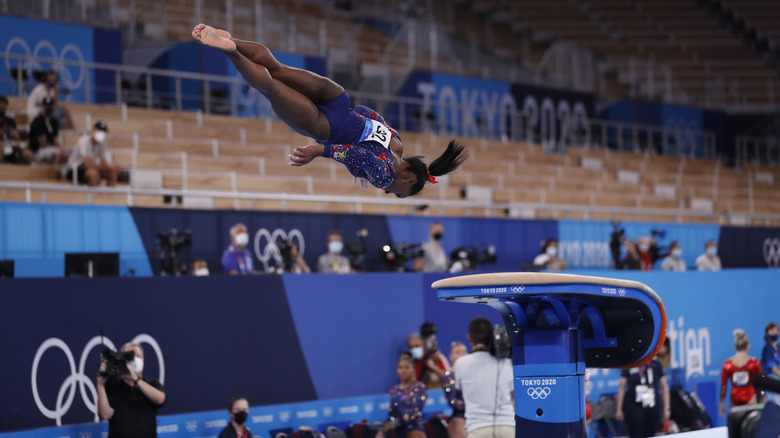 Simone Biles in air mid-vault