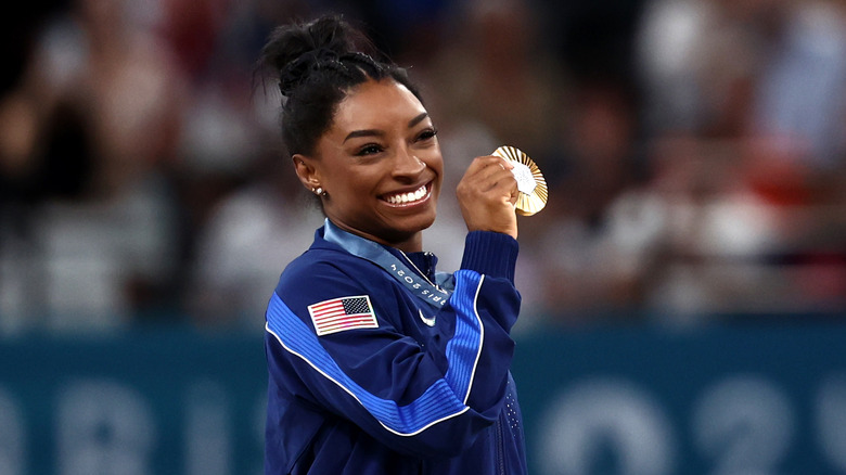 Simone Biles holding gold medal