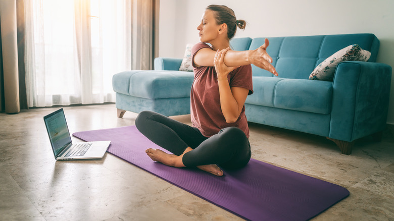 Woman stretching in front of a laptop