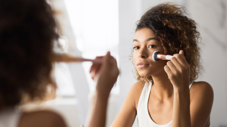 woman applying blush