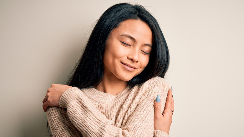 happy woman hugging herself