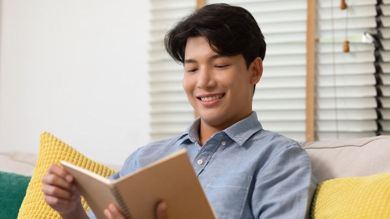 man smiling and reading
