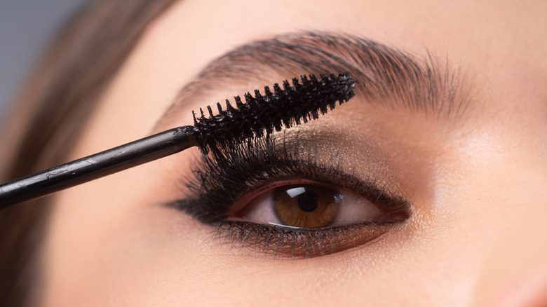 woman putting on mascara