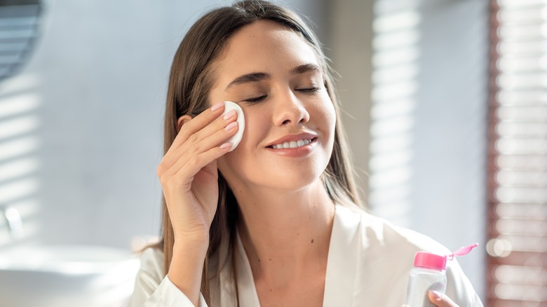 woman cleansing face in bathroom